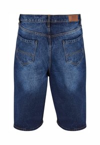 Tummansiniset farkkuhousut, joissa on viisi taskua, suora leikkaus ja nahkalappu. Vaaleampi kuluminen tuo tekstuuria kankaaseen.