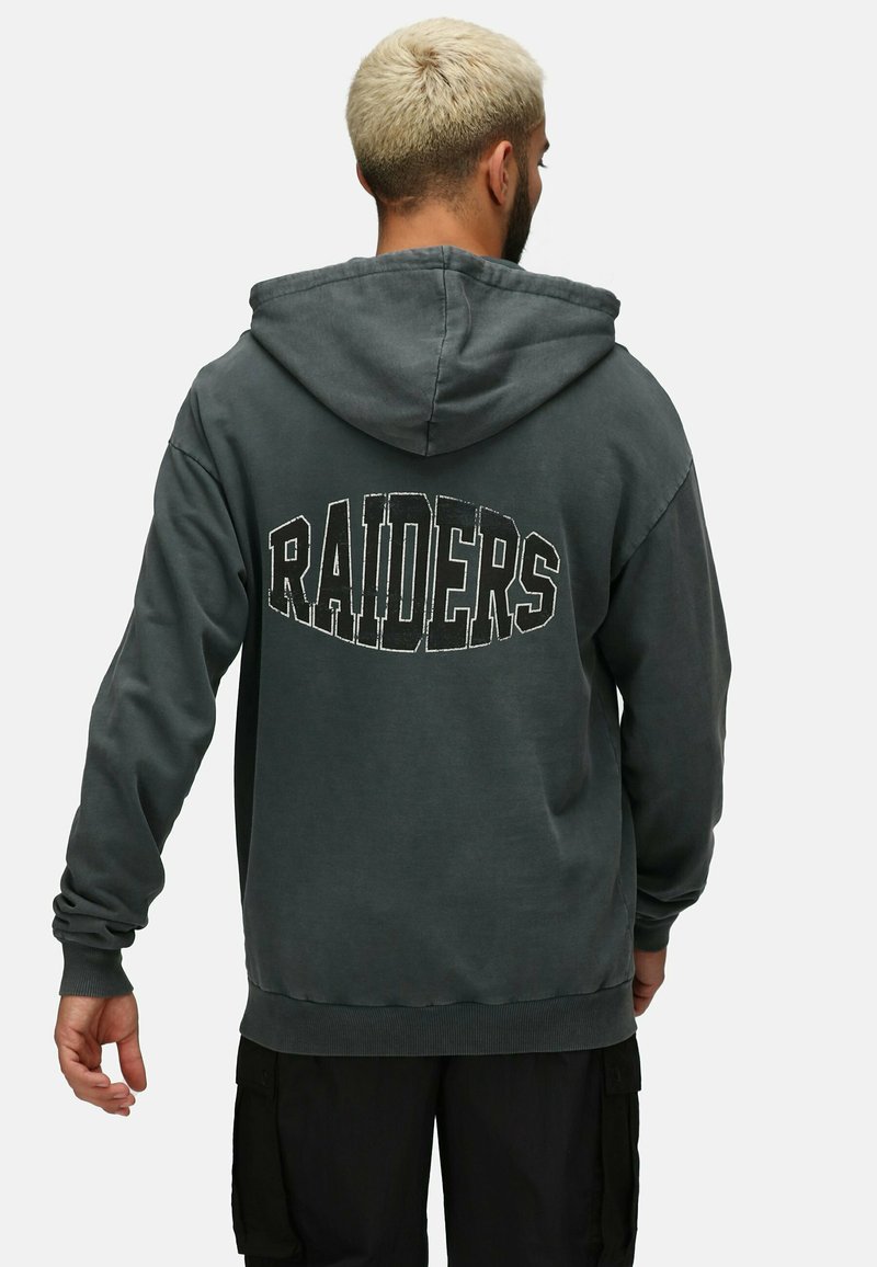Sudadera de color gris oscuro con una gran impresión de "RAIDERS" en la parte posterior, con una tela texturizada y capucha con cordones. Puños y dobladillo acanalados.