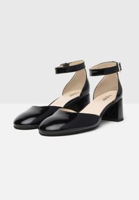 Scarpe con cinturino alla caviglia in vernice nera, con punta rotonda e tacco a blocco. Presentano una texture liscia e una chiusura con fibbia regolabile.
