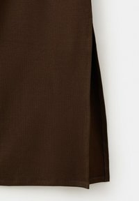 Mørkebrun ribstrikket stof med en sideslids, der viser detaljerede syninger langs kanten på en hvid baggrund.