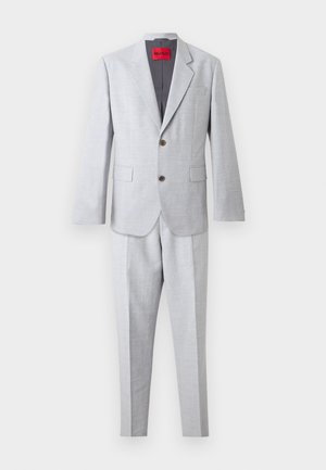 Világosszürke kétdarabos öltöny kétgombos, bevágott hajtókás blézerrel, fedeles zsebekkel és hozzáillő egyenes szárú nadrággal.