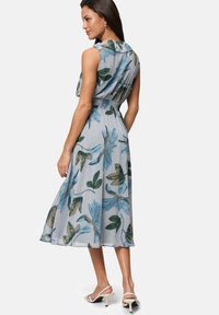 Blumen-Midi-Kleid in Hellblau mit grünen Blättern, tailliertem Schnitt und Kragen-Detail; leichtes Material mit fließender Silhouette.