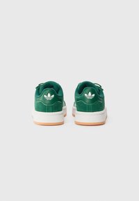 Grønne semskede sneakers med hvite gummisåler, oransje detaljer og en logo bak. Minimalistisk design med polstret ankelstøtte.
