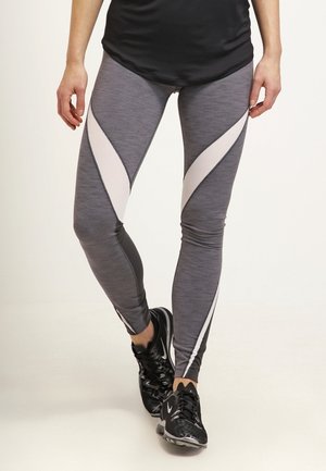 Leggings de sport gris avec des panneaux courbes blancs contrastants. Fabriqués dans un tissu extensible et texturé, au design ajusté avec une finition lisse.