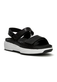 Zwarte sandaal met gestructureerde stofbanden en verstelbare klittenbandsluiting, met een gewatteerde zool en een witte plateauzool.