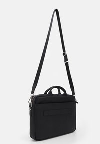 Sort laptop taske lavet af struktureret læder. Har dobbelte top håndtag, justerbar rem og lynlås lukning. Enkelt design med minimale detaljer.