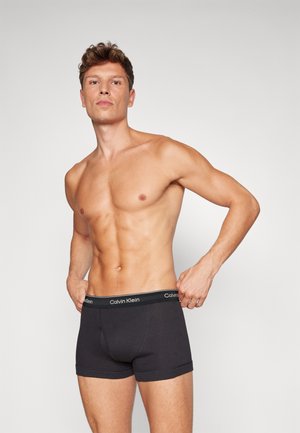 Schwarze Baumwoll-Boxershorts mit einer engen Passform, elastischem Bund mit "Calvin Klein"-Markenlogo und einer glatten Textur.