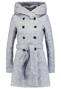 Ljust grå dubbelknäppt ullkappa med bred krage, svarta knappar, sidofickor, långa ärmar och ett matchande tygbälte knutet vid midjan.