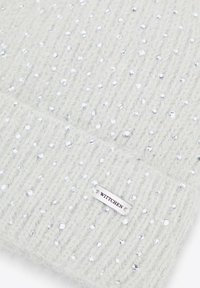 Světle šedá pletená čepice s stříbrnými flitry, s žebrovanou strukturou a malou bílou štítkem s ražbou "WITTCHEN".