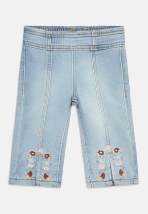 Pantalones cortos de mezclilla azul claro hasta la rodilla con costuras verticales y bordado floral cerca del dobladillo en cada pierna.