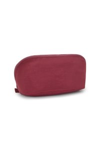 Neceser de tela burdeos con forma redondeada, textura suave y cierre superior con cremallera. Presenta una pequeña pestaña lateral para un manejo fácil.