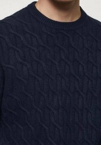 Pull en maille torsadée bleu marine avec un motif texturé, doté d'une encolure ras du cou et en matière douce en mélange de laine. Design distinctif en relief.