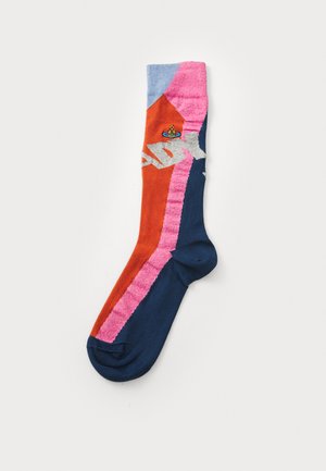 Fargerike sokker med oransje, rosa og blå seksjoner med en teksturert design. Inkluderer en liten logodetalj nær toppen. Laget av bomullsblanding.