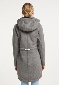 Šedá mikina s kapucí se staženým pasem, šňůrkou a prostornou kapucí. Hladký materiál a dlouhé rukávy, navrženo pro teplo a pohodlí.