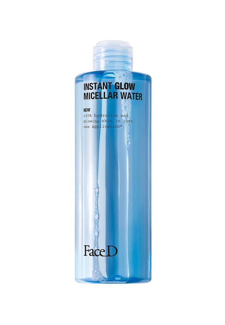 Bottiglia trasparente di plastica blu di acqua micellare con tappo a vite. Etichette di testo nero sul davanti che dettagliano i benefici del prodotto e il nome del marchio.
