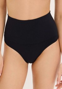 Short taille haute noir en tissu lisse et extensible. Doté d'une large taille élastique et de bords sans couture pour un confort optimal et une finition propre.