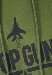Oliivinvihreä huppari, jossa on näkyvä musta lentokonesuunnittelu ja teksti "TOP GUN." Pehmeä kangas, jossa on tekstuurinen pinta ja säädettävät nyörit.