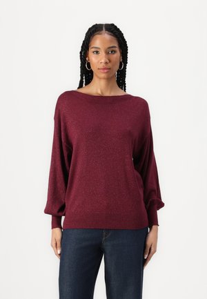 Burgundy knit sweater with a loose fit, wide neckline, and ribbed cuffs. Blends subtle shimmer for added texture. Worn over dark jeans.