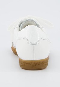 Sneaker in pelle bianca con finitura liscia, design con lacci e suola in gomma marrone con nome del marchio in rilievo sul tallone.