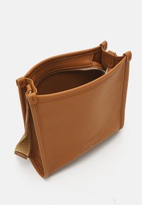 Borsa a mano in pelle marrone chiaro con finitura testurizzata, forma rettangolare, chiusura zip superiore e dettagli del logo discreti sul davanti.