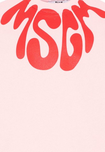 Tissu rose avec de grandes formes abstraites rouges audacieuses ressemblant à des lettres déformées imprimées près du centre supérieur.