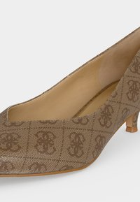 Escarpin marron à talon bas avec un bout carré, doublure intérieure beige et un motif à carreaux discret avec des motifs floraux.