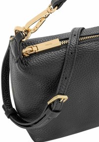 Czarna skórzana torebka o teksturowanej powierzchni, złotym okuciu, z zamknięciem na zamek błyskawiczny i regulowanym paskiem. Posiada smukły design.