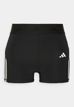 Svarte idrettsshorts laget av elastisk stoff. Har en bred svart linning med prellet logo og hvite sidestriper.