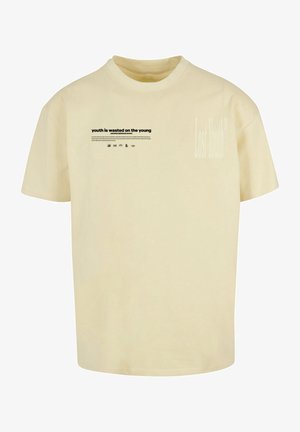 T-shirt en coton beige à manches courtes, avec un motif texte imprimé à l'avant et la phrase « Lost Youth » sur le côté.
