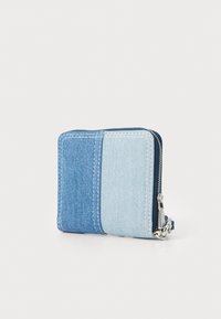 Denim wallet featuring a zip closure, two-tone blue panels, and white stitching. Compact rectangular shape with a textured surface.