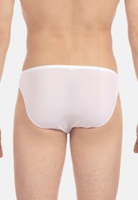 Weiße Herrenunterwäsche aus glattem Stoff, mit einem minimalistischem Design, niedrig geschnittenem Bündchen und ohne sichtbare Muster oder Akzente.