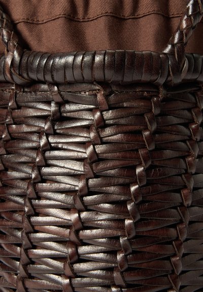 Cesta de couro castanho escuro tecido com uma superfície texturizada, apresentando uma borda resistente e um forro de tecido castanho suave na parte superior.