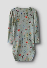 Floral baby onesie van zachtgroene stof, met verschillende kleurrijke bloemen- en paddenstoelpatronen, lange mouwen en een ronde halslijn.