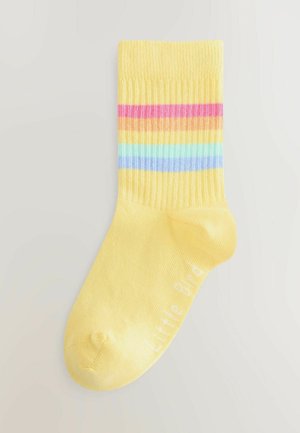 Yellow cotton sock with ribbed texture, featuring horizontal stripes in pink, orange, blue, and green. "Little Bird" is printed in white.