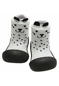 Calcetines de bebé blancos con un patrón de puntos negros que asemeja la cara de un perro, con suelas de goma negras y orejas en la parte superior.
