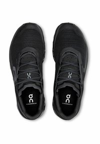 Czarne buty biegowe z siateczkową cholewką, wyściełanym kołnierzem i gumową podeszwą. Zawierają sznurowadła oraz logo na języku i wkładce.
