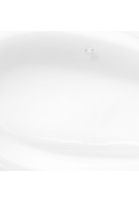 Goutte d'eau claire unique suspendue au-dessus d'une surface liquide blanche lisse, capturant le moment avant l'impact.