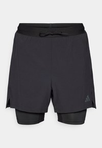 Μαύρο αθλητικό σορτς με εφαρμοστή εσωτερική στρώση. Διαθέτει σφιχτή μέση με κορδόνι και πλευρικές σχισμές για ευκολία στην κίνηση. Περιλαμβάνει διακριτική λεπτομέρεια με λογότυπο.