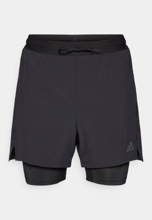 Schwarze sportliche Shorts mit einer enganliegenden inneren Schicht. Verfügt über einen Kordelzug in der Taille und Seitenschlitze für mehr Bewegungsfreiheit. Mit dezentem Logodetail.