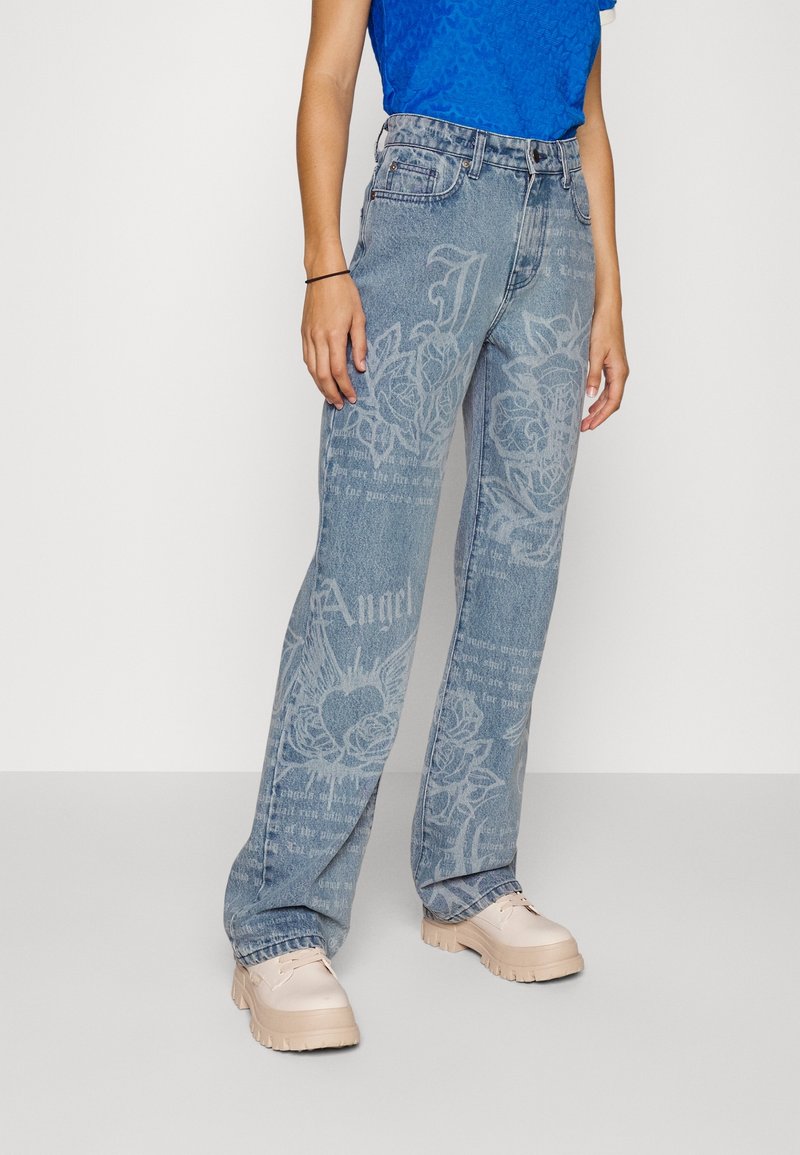 Ljusblå denimjeans med en lös passform, med urblekta botaniska tryck och textmönster. Bärs med ljusbeige chunky-skor.