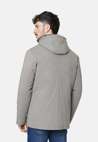 Abrigo gris texturizado con capucha, que presenta un corte recto y detalles de costura mínimos. Diseñado para un ajuste casual, adecuado para el clima fresco.