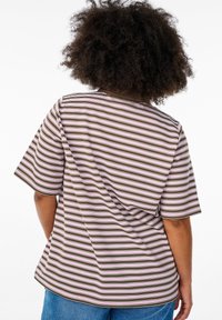 T-shirt rayé présentant des lignes horizontales de couleur marron, rose et crème, avec une coupe décontractée et des manches courtes et larges.