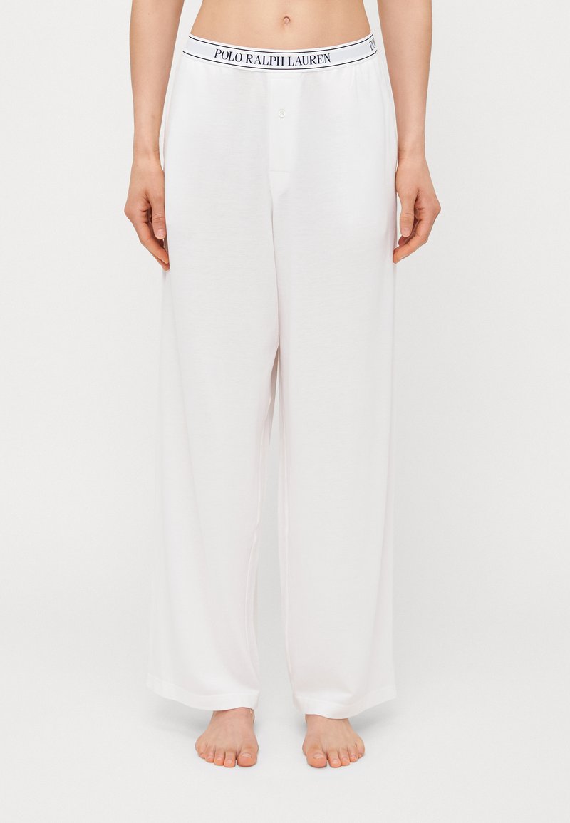 Pantaloni de pijama albi, confecționați dintr-un material moale, având un talie cu șnur și cu marca "POLO RALPH LAUREN" și o croială lejeră.