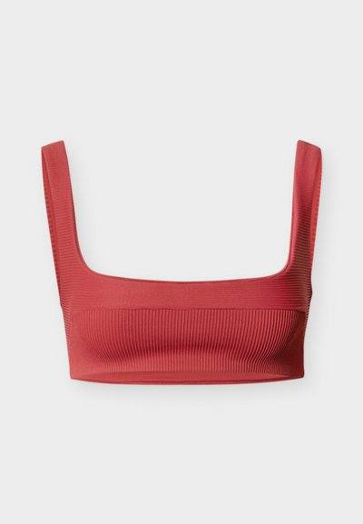 Κόκκινο κορσάζ με ριμπ ύφανση, φαρδιές τιράντες, τετράγωνη λαιμόκοψη και υφή στο ύφασμα. Μινιμαλιστικός σχεδιασμός, λεία επιφάνεια και εφαρμοστό σχήμα.