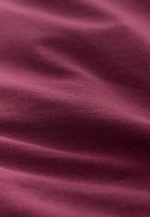 Burgundijas audums ar gludu tekstūru, kam ir smalki krunciņas un mīksta, elastīga sajūta. Tuvplāna skats izceļ tā vienmērīgo krāsu un audumu.