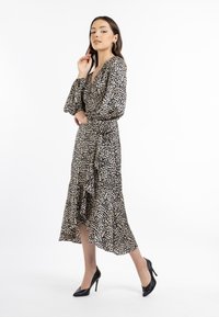 Meekka leopard print baarikottu, jonka materiaali on kevyt. Siinä on V-pääntie, pitkät puff-hihat, röyhelöhelma ja musta korkokenkä.