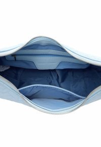 Intérieur d'un sac à main matelassé bleu clair avec une poche zippée et un compartiment ouvert, doublé d'un tissu bleu assorti.