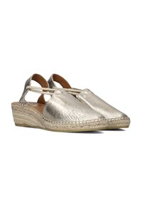 Metallic gold espadrille wedges with cut-out sides, woven jute outsole, and smooth leather upper. Features elastic straps for a secure fit.