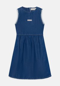 Dongerikjole uten ermer i dyp blå, med tettsittende overdel og utsnittet skjørt. Har en etikett med "Calvin Klein" på brystområdet.