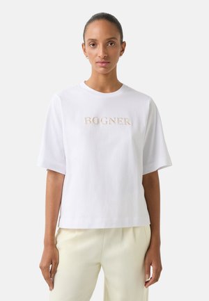 T-shirt en coton blanc à manches courtes, arborant le logo brodé "BOGNER" en beige sur la poitrine. Coupe ample, texture lisse.